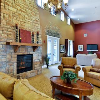 A cozy living room with a stone fireplace, comfortable seating, and elegant decor.