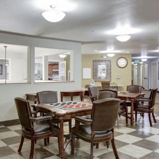 An empty dining area with tables and chairs arranged on a checkered floor.