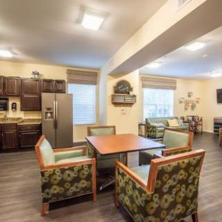 A cozy living area featuring a kitchen, table, and chairs with floral upholstery.