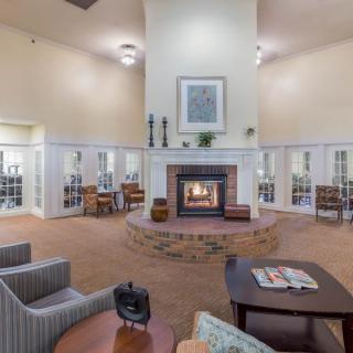A cozy lounge with a central fireplace and modern seating arrangements.