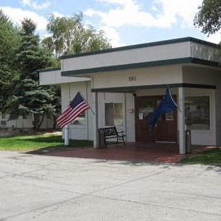 A small government building featuring American and state flags.