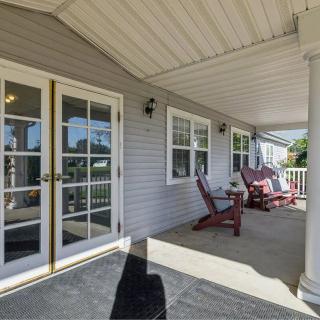 A cozy covered porch with outdoor seating and French doors, providing a relaxing space to enjoy the outdoors.