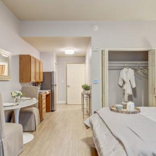 A cozy studio apartment featuring a minimalist design with a comfortable sleeping area, small kitchenette, and a dining table.