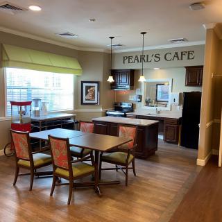 An inviting indoor cafe setting with tables and chairs, known as 'Pearl's Cafe'.
