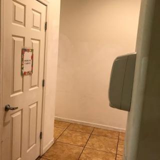 A view of a hallway featuring a door and tiled flooring.