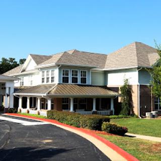 A well-designed residential building with a landscaped entrance on a sunny day.