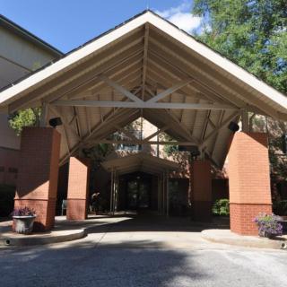 A spacious covered entrance with brick pillars leading into a building.