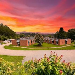 A serene sunset casts vibrant colors over a peaceful community landscape.