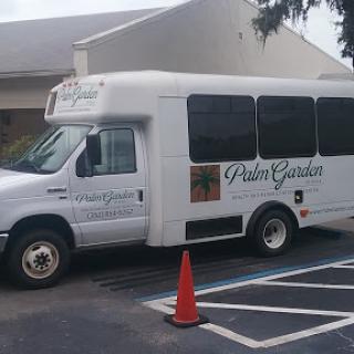A shuttle bus parked in a lot, advertising Palm Garden.