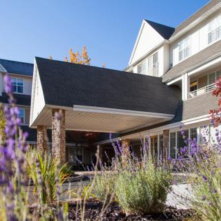 A modern residential building with landscaped surroundings and a welcoming entrance.
