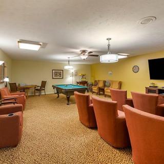 A cozy recreation room featuring a pool table, comfortable seating, and a television for entertainment.