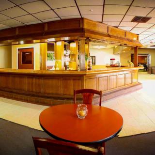 An empty bar area with wooden decor and a small table in the foreground.