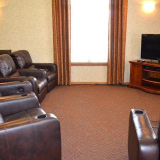 A cozy living room with leather sofas and a TV setup.