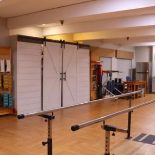 A rehabilitation center equipped with parallel bars and other exercise equipment for physical therapy.