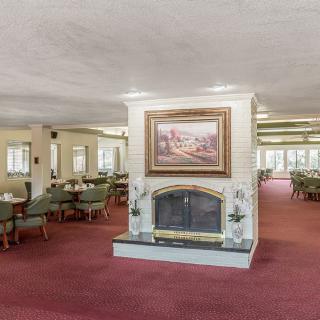 A spacious dining area with a central fireplace and elegant furnishings.
