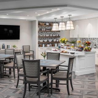 A modern dining area featuring a breakfast buffet with neatly arranged tables and chairs.