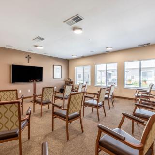A small chapel with arranged seating and a television on the wall.