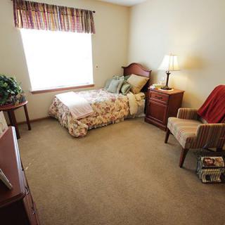 A cozy bedroom with a single bed and comfortable seating.