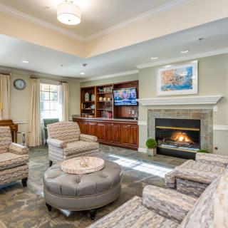 A cozy and modern living room with a fireplace, comfortable seating, and a television.