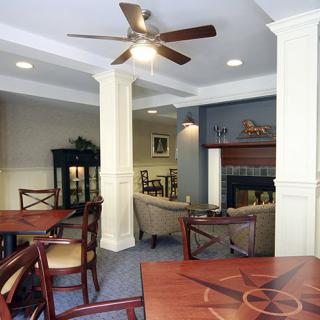 A cozy living room with a seating area, fireplace, and ceiling fan.