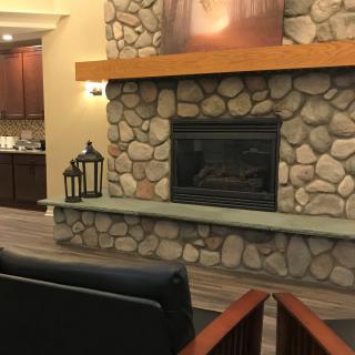 A cozy living room featuring a stone fireplace and modern decor.