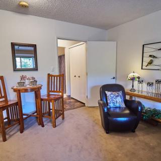 A cozy living room with a leather armchair and wooden table set.