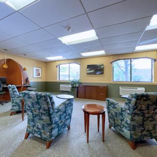A cozy lounge area with comfortable seating, natural light filtering through the windows, and a welcoming atmosphere.