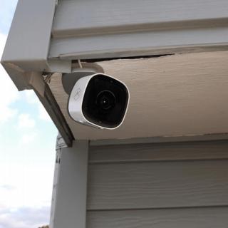 An outdoor security camera mounted on a building corner for surveillance.