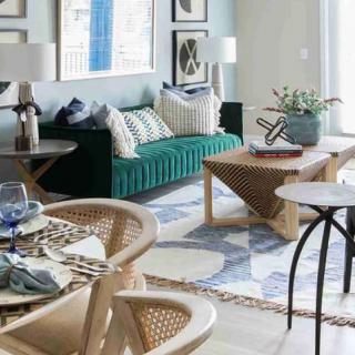 A stylish living room with a green sofa, patterned rug, and modern furniture.