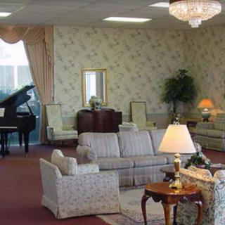 An elegantly decorated living room featuring a grand piano, sofas, and intricate lighting.