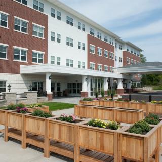 A modern building with a landscaped garden featuring wooden planters.
