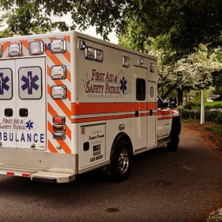 An ambulance parked on a tree-lined street, ready to assist in emergencies.