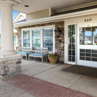 The image shows the entrance to a building with benches and decorative stonework.