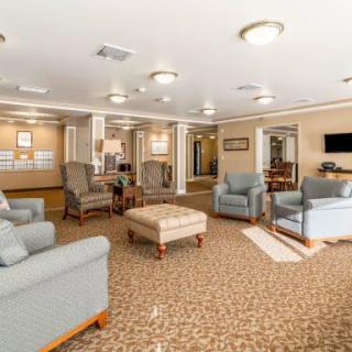 A spacious lounge with comfortable seating and a carpeted floor, featuring stylish lighting and decor.