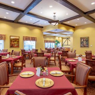 A well-lit, elegantly designed restaurant dining area with neatly arranged tables and chairs.