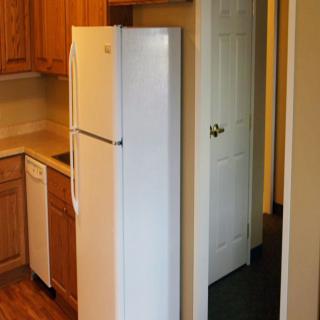 Refrigerator placement in a compact kitchen layout.