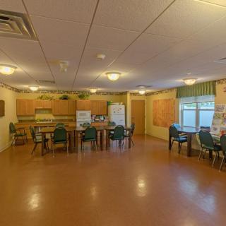 A spacious dining and kitchen area with tables and chairs arranged neatly.