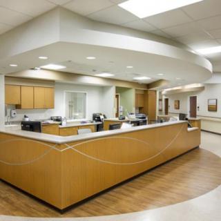 A clean and modern hospital reception area with a large desk.