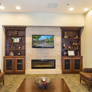 Cozy living room featuring a central fireplace, built-in bookshelves, and a mounted television.