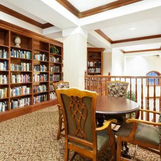 A cozy library corner with bookshelves, a table, and chairs for reading.