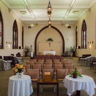 Interior view of a small chapel with arranged seating and decorative elements.
