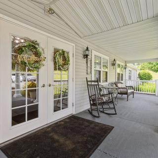 A welcoming porch with rocking chairs and decorative wreaths on the doors.