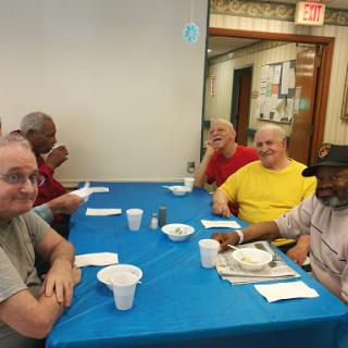 A group of elderly men enjoying a meal together in a social setting.
