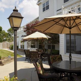 A charming outdoor patio area with tables, chairs, and umbrellas next to a building.