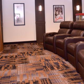 A cozy home theater lounge featuring comfortable recliners and stylish decor.