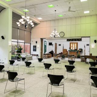 A spacious event venue set up with chairs, featuring modern lighting and decor.