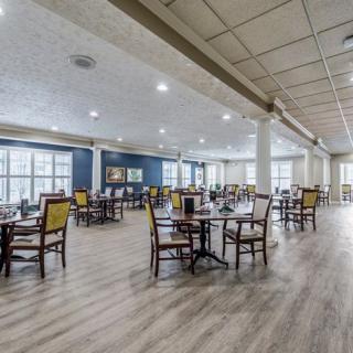A spacious and well-lit dining area with neatly arranged tables and chairs.