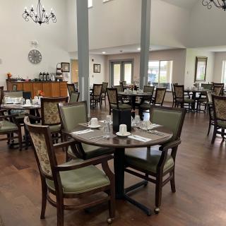 A spacious dining room with neatly arranged tables and chairs in a well-lit indoor setting.