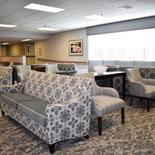 A spacious waiting area with patterned sofas and chairs, featuring a modern interior design.