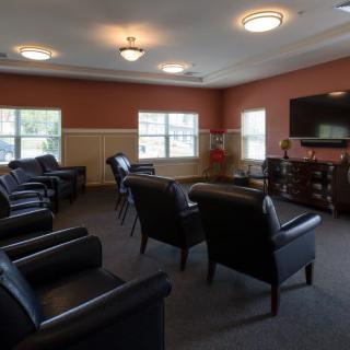 A spacious lounge with comfortable seating and a large television.